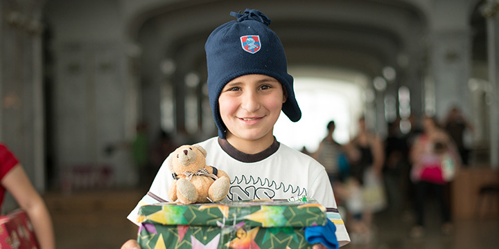 Boy wearing hat and holding shoebox