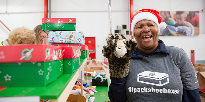 Volunteer holding hand puppet and smiling