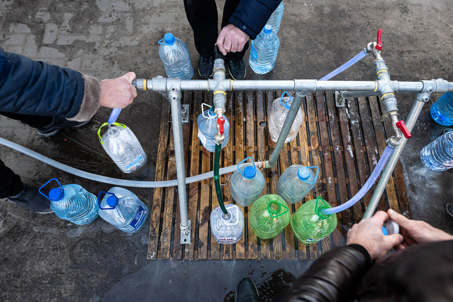 MANY WAR-WEARY RESIDENTS FLOCK TO OUR DISTRIBUTION CENTERS FOR WATER TO DRINK AND CLEAN WITH.