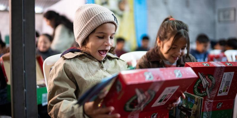 These girls are astonished after seeing what's inside their shoebox gift for the first time.