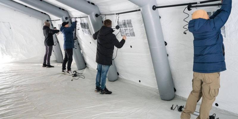 The team works to install lights in one of the warming centre tents.