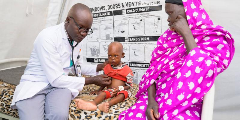 Toma, right, and her grandson, Ahmed, are seen by Dr. Rodgers as our staff nurture the little boy back to full health.