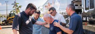 Edward Graham praying with staff