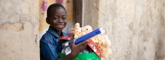 Boy holding cuddly toy and shoebox