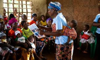 A MATERNAL CHILD HEALTH LEADER MOTHER TEACHES OTHER PARENTS ABOUT PROPER CARE DURING PREGNANCY.