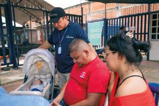 MILUIA AND JOEL PRAY with a chaplain at our clinic.