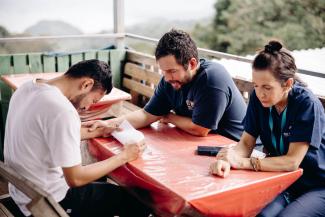 In the remote mountains of San Miquel, El Salvador, Pastor Peter Rodriguez (middle) and Marta Zoch (right) provide spiritual support for a patient.