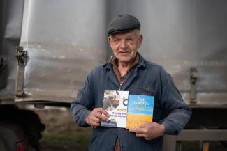 Vasyl gratefully displays the gardening guide and copy of the New Testament he received from Samaritan’s Purse.