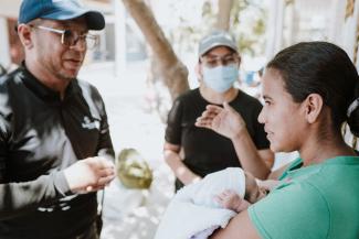Christian Nuñez (left), a trained Samaritan’s Purse chaplain, shares God’s love with a patient at the clinic. Preaching the Gospel remains our goal as we serve Colombian mothers in Jesus’ Name.