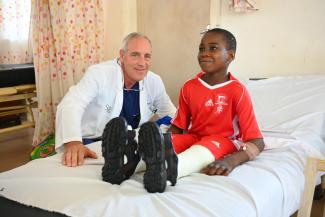 Dr. Greg Hellwarth, an orthopedic surgeon serving on the team in Nigeria, checks in on Amos following his successful surgery to fix his bow legs.