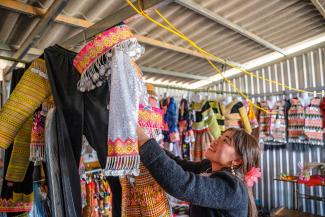 HAI CREATES beautiful clothing in her tailor shop.