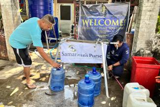 Community members in the Philippines fill jugs with clean, drinkable water out of the Samaritan’s Purse water taps.