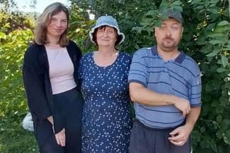 Grateful for how the firewood will keep her family warm this winter, cancer survivor Olena (center) said, “Now I know I am not alone—and that gives me strength to keep going.”